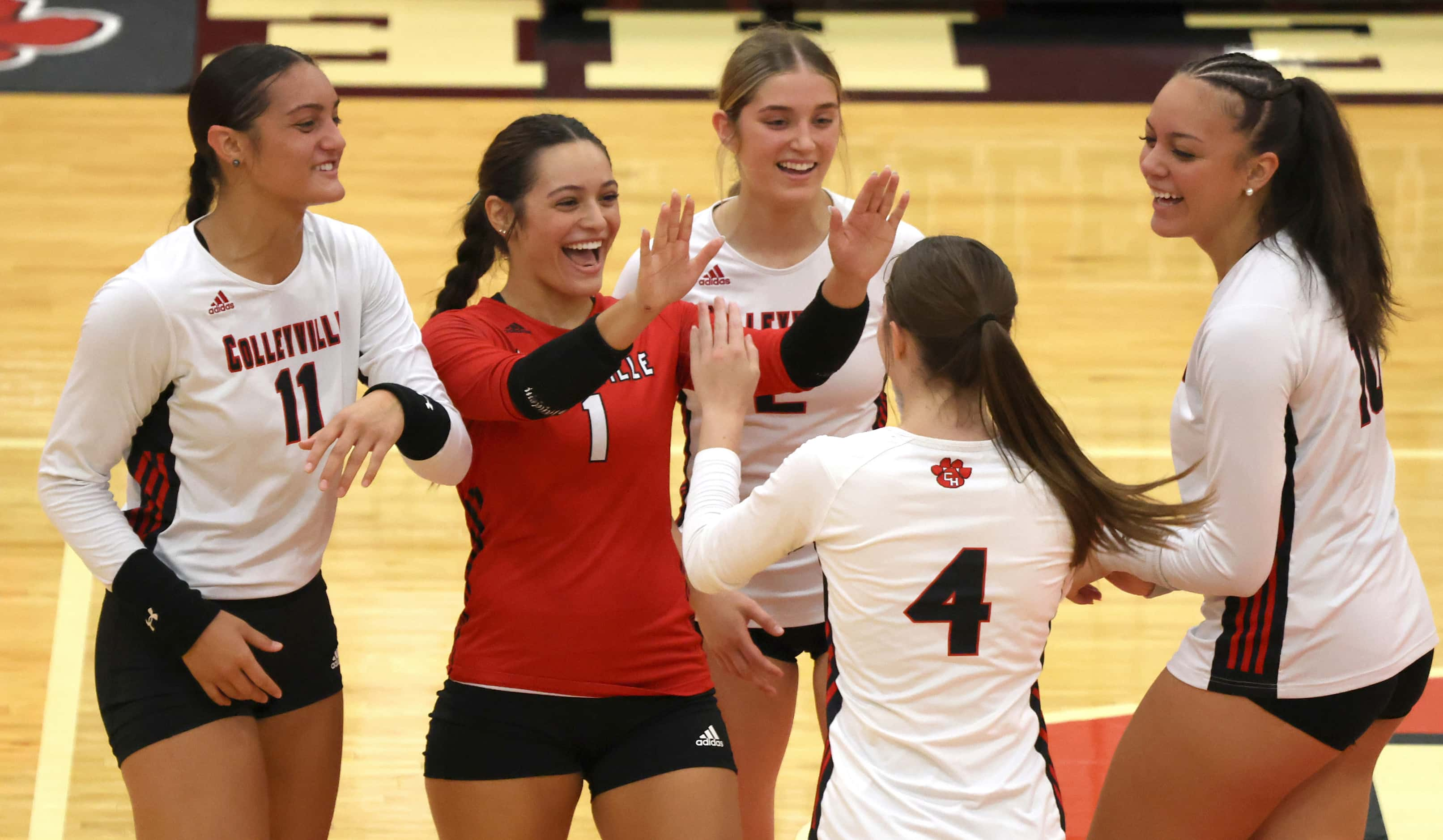 Colleyville Heritage outside hitter Georgia Smith (4), back to camera, receives a hearty...