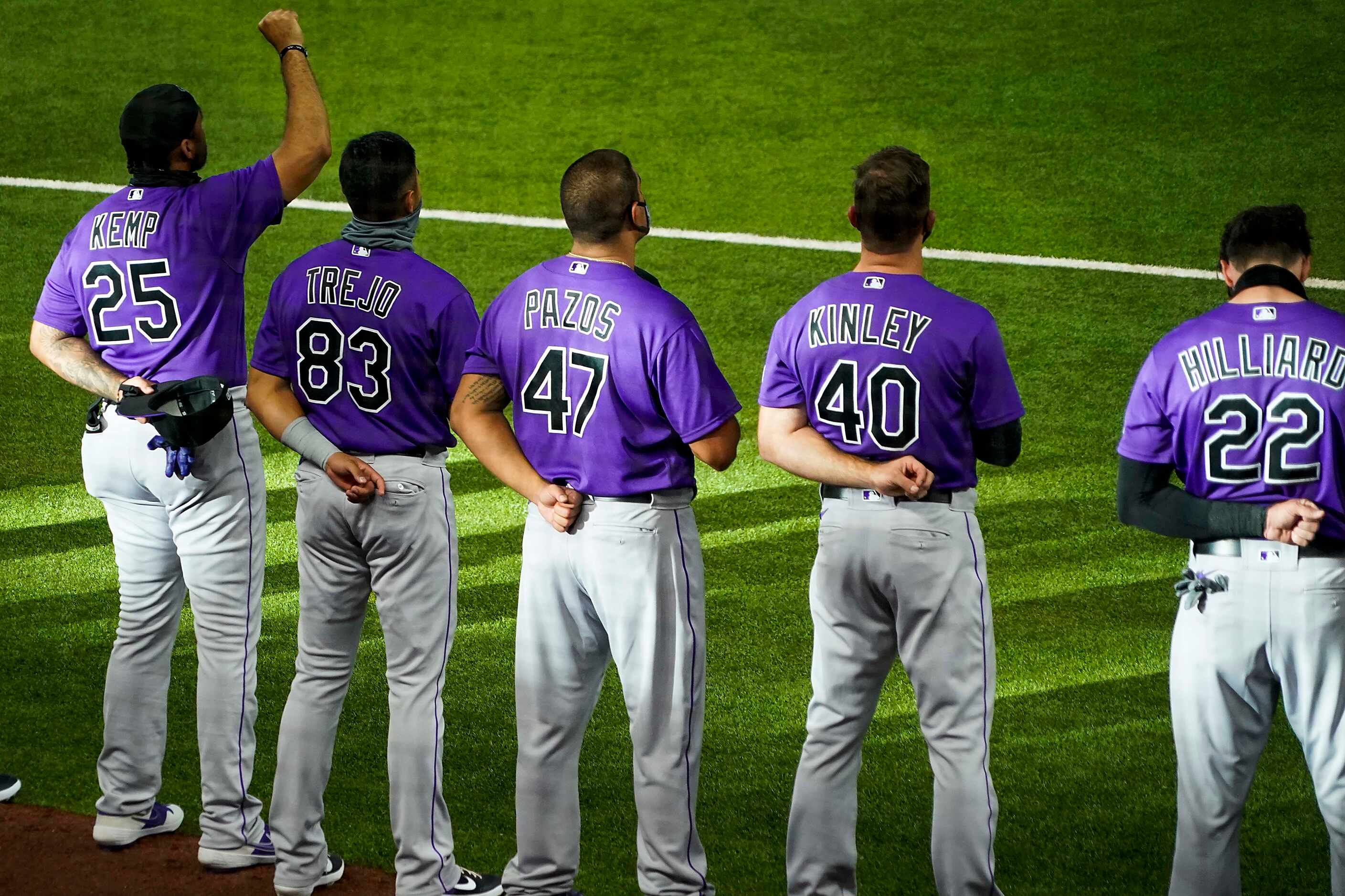 Colorado Rockies outfielder Matt Kemp raises his fist as the team stands for the national...
