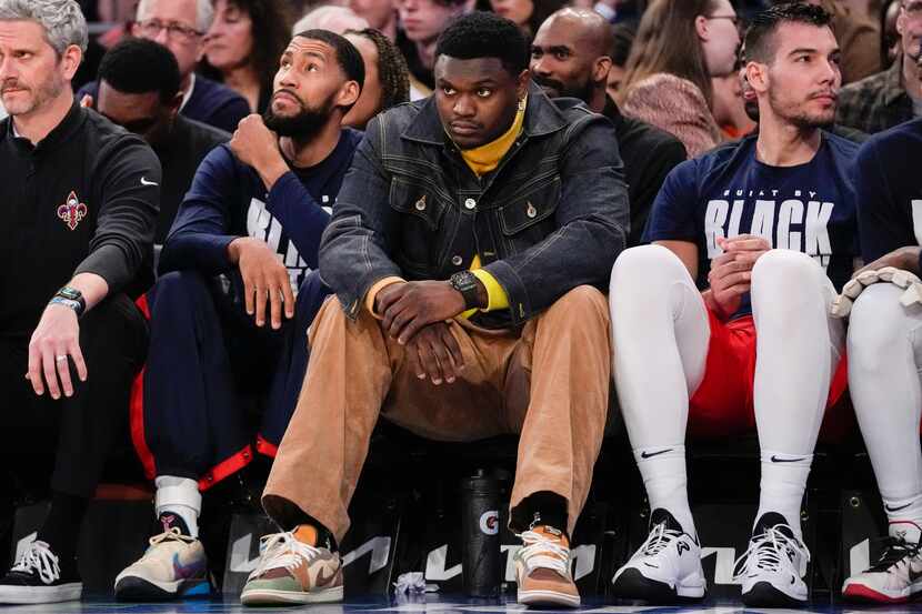 New Orleans Pelicans forward Zion Williamson, center watches from the bench during the...