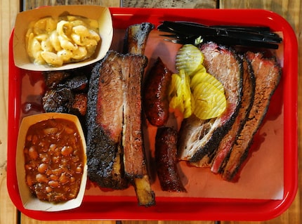 A tray full of burnt ends, brisket, beef rib, Texan spicy sausage, Italian sausage, with...