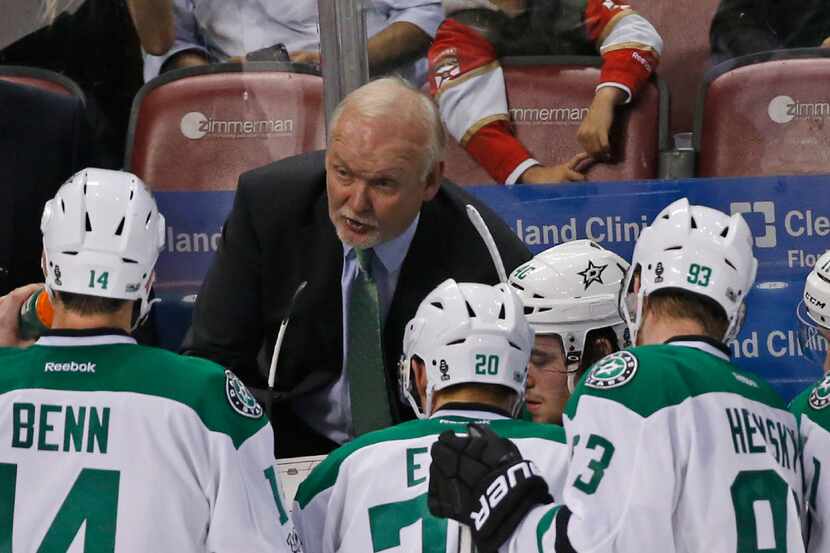 Dallas Stars head coach Lindy Ruff, center rear, talks with players during the third period...