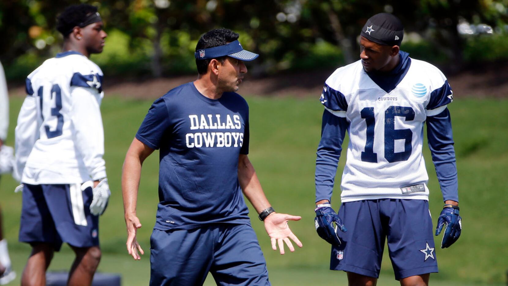 Dallas Cowboys wide receivers coach Sanjay Lal talks to receiver Cedrick Wilson (16) during...
