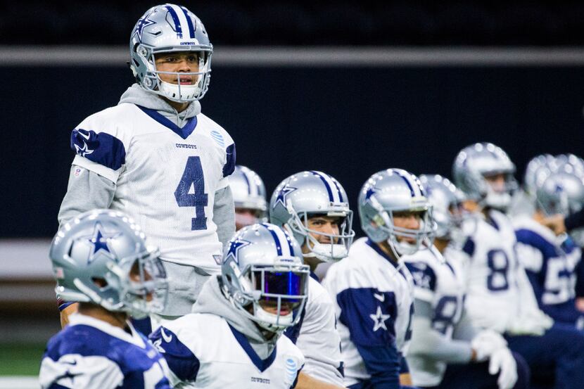 Dallas Cowboys quarterback Dak Prescott (4) stands over his teammates during practice on...