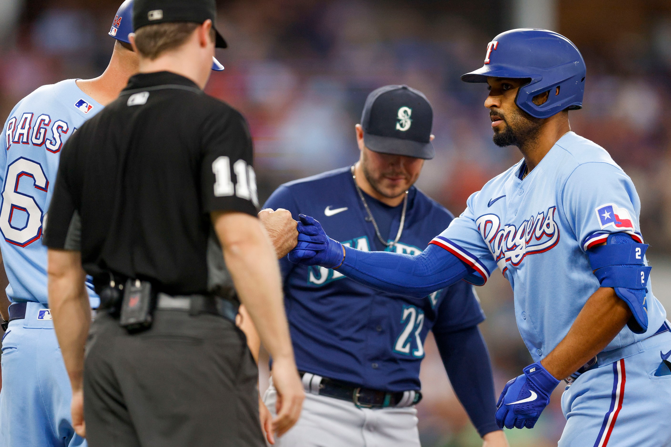 Texas Rangers second baseman Marcus Semien (2) fist bumps first base coach Corey Ragsdale...