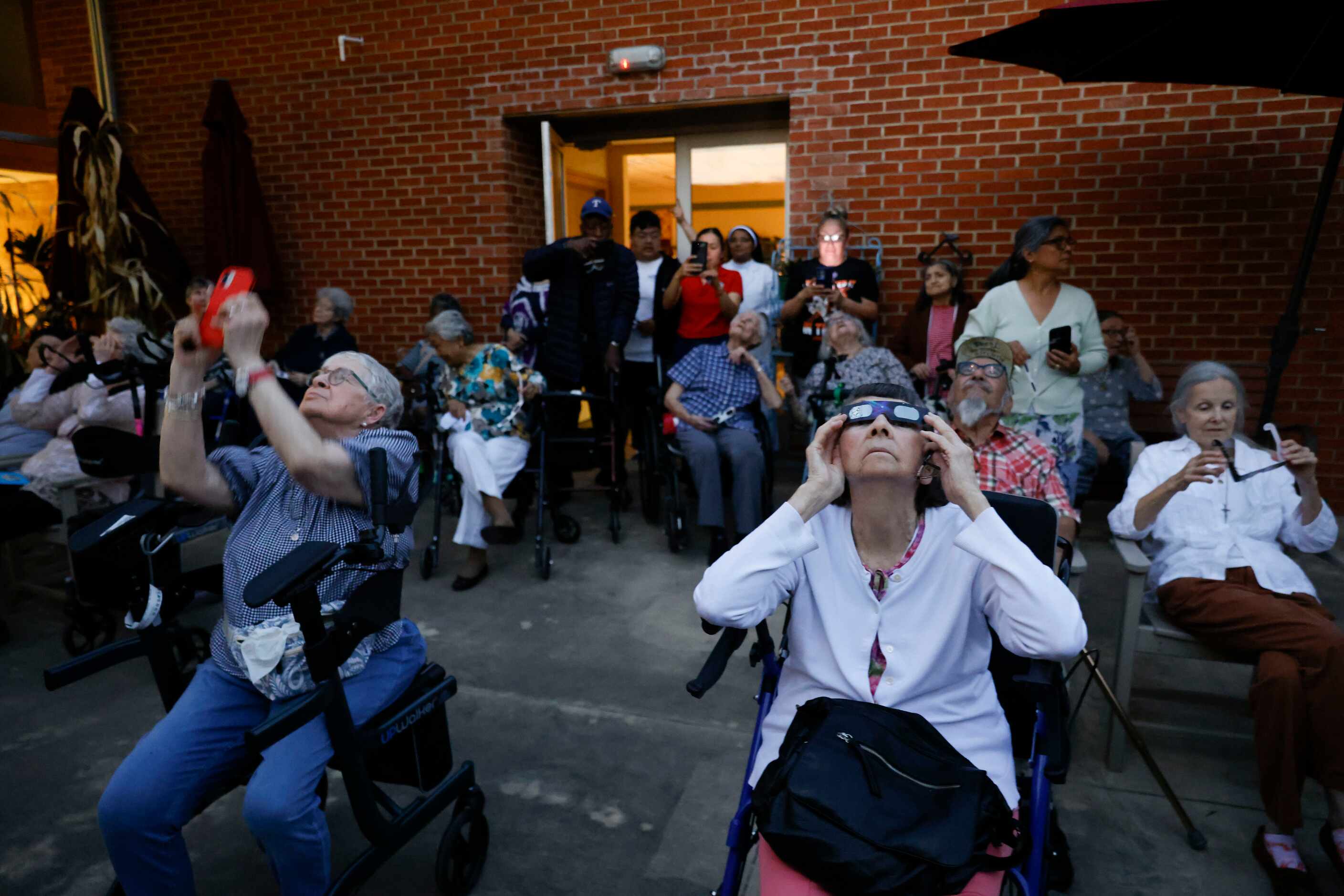 St Joseph's Residence Inc. residents look up to view the totality of the solar eclipse on...