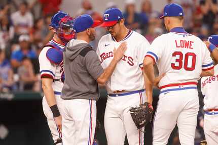 Texas Rangers manager Chris Woodward (8) talks to Texas Rangers starting pitcher Dane...