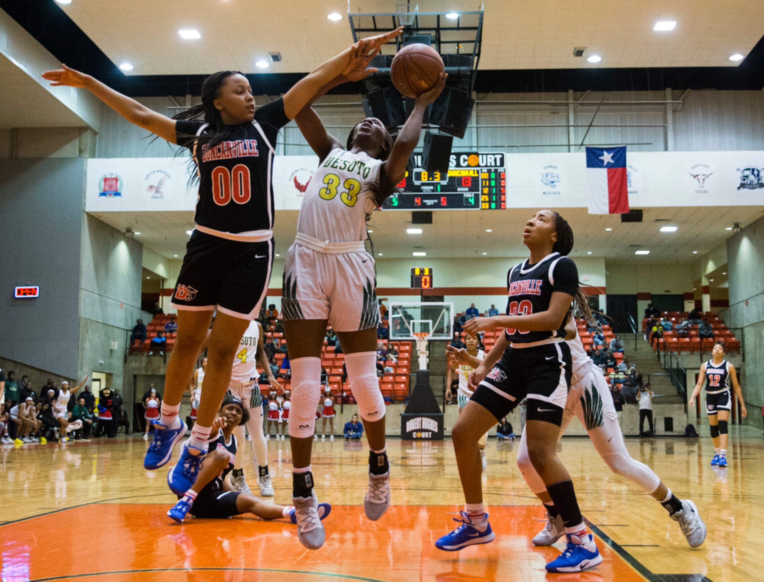 DeSoto's Amina Muhammad (33) goes up for a shot while Duncanville's Hope LeMelle (00)...