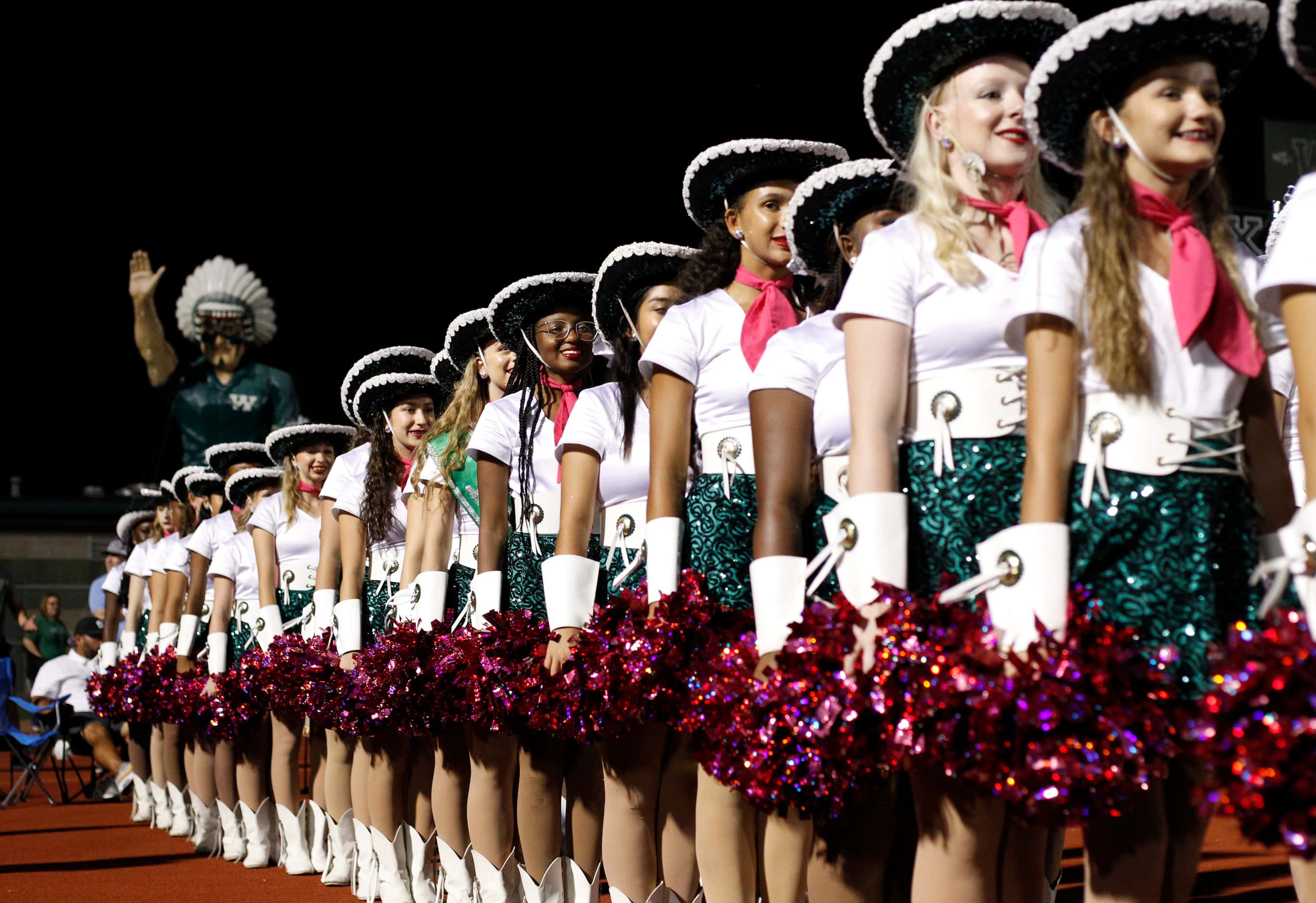 Waxahachie drill team members await taking the field for their performance at halftime of...