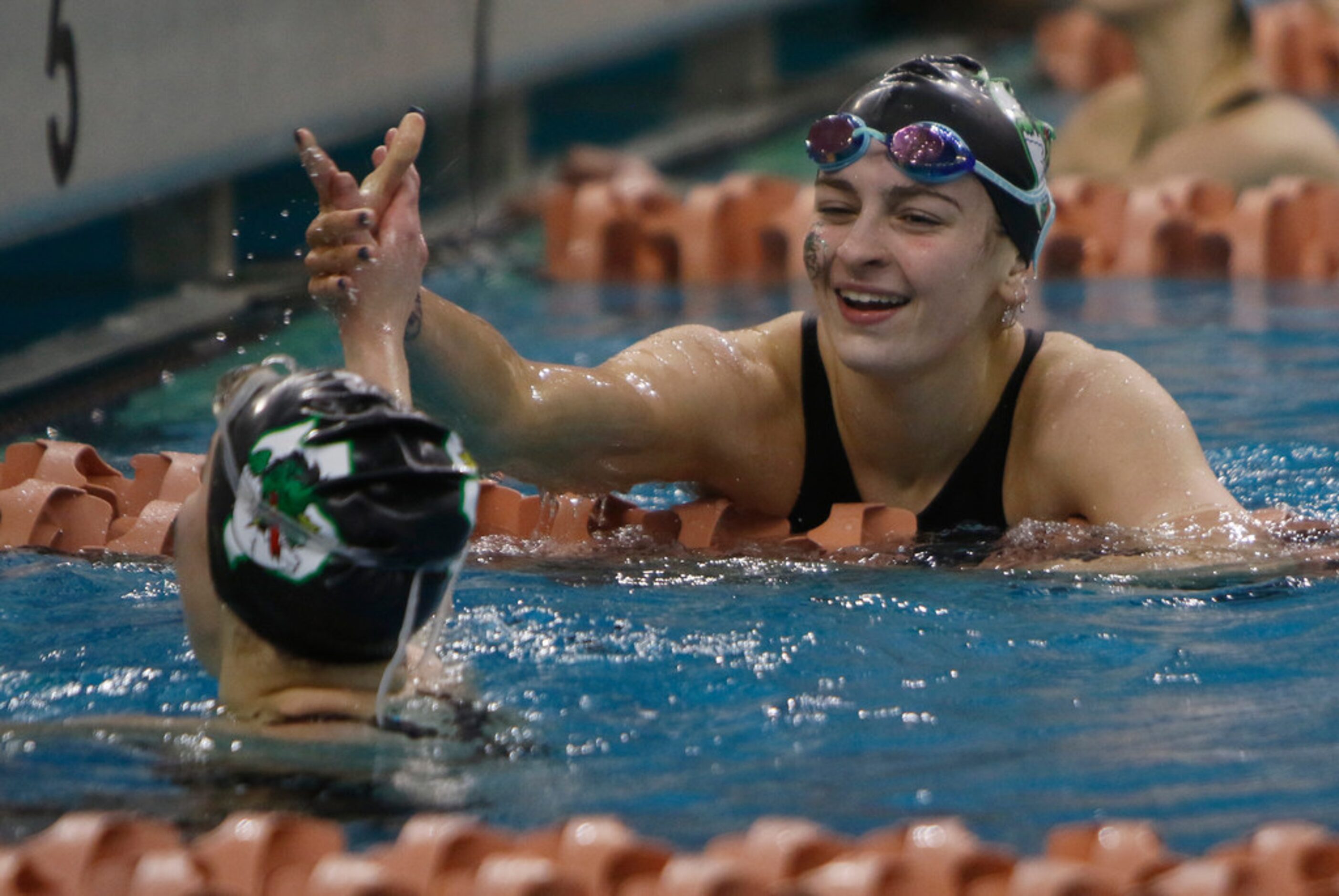 Southlake Carroll's Riley Francis reaches to give teammate Kit Kat Zenick a congratulatory...