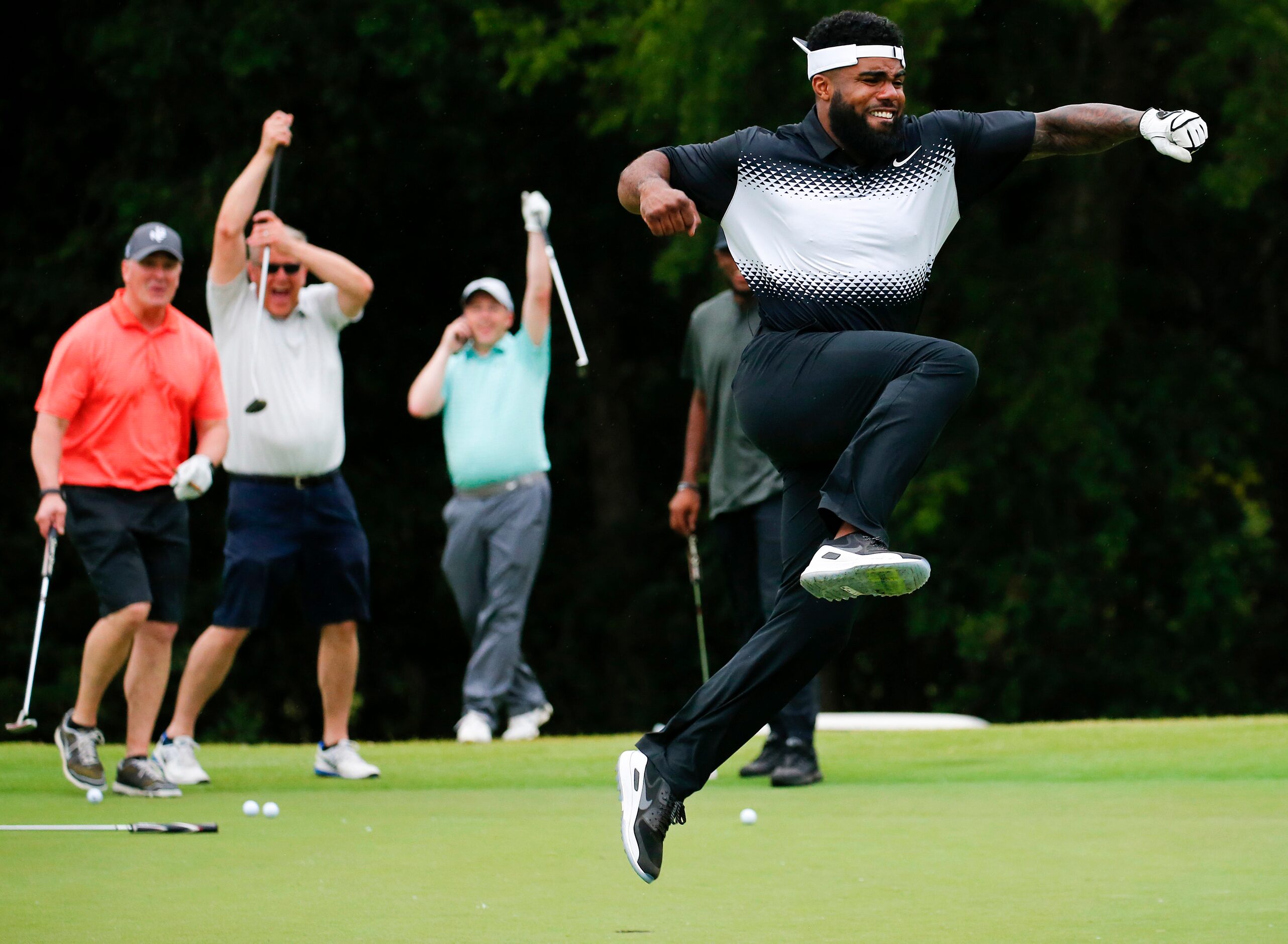 Dallas Cowboys RB Ezekiel Elliott celebrates his 25 ft. putt that banked off the back of...