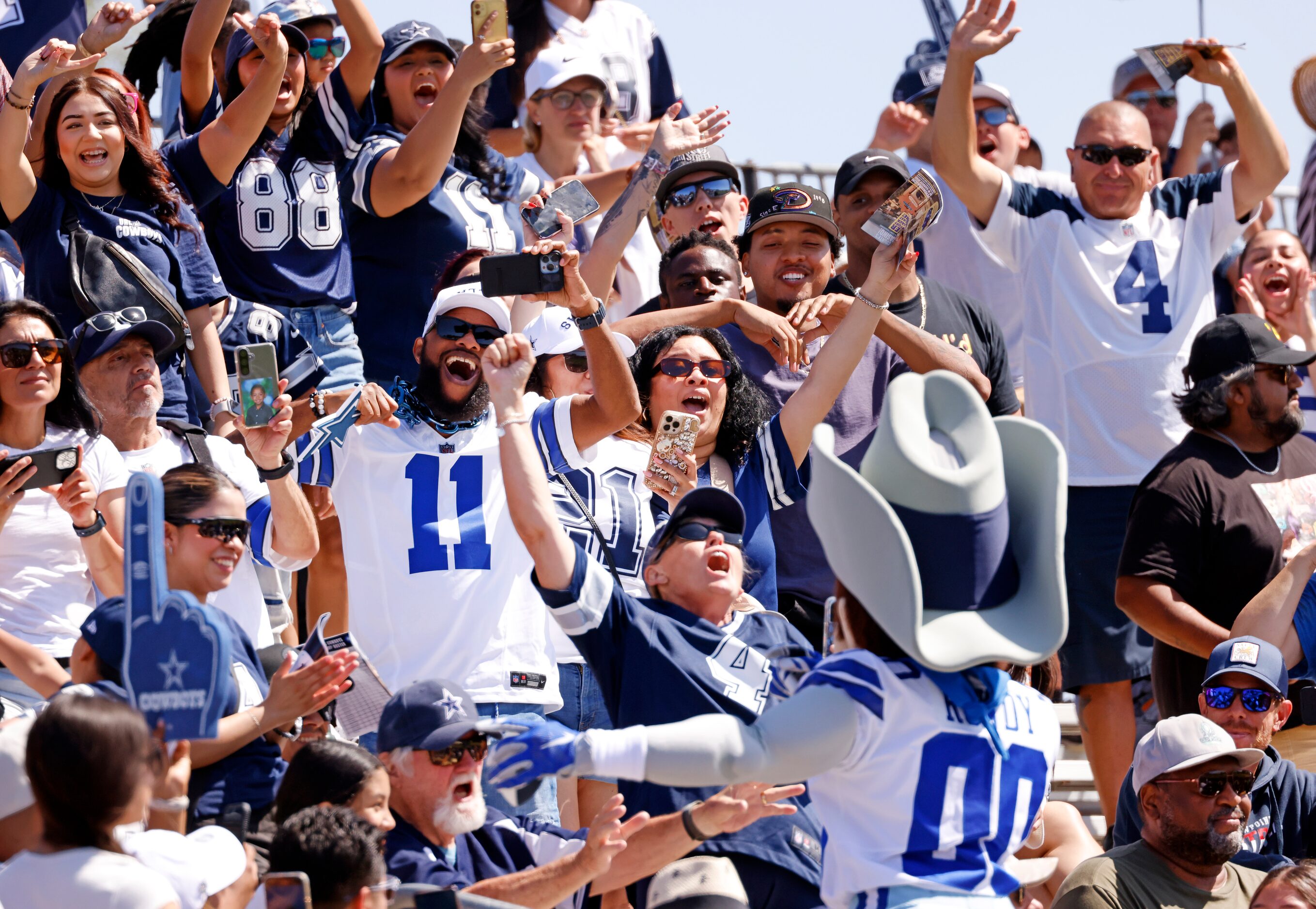 Dallas Cowboys mascot Rowdy leads fans in a competitive cheer in the stands during training...