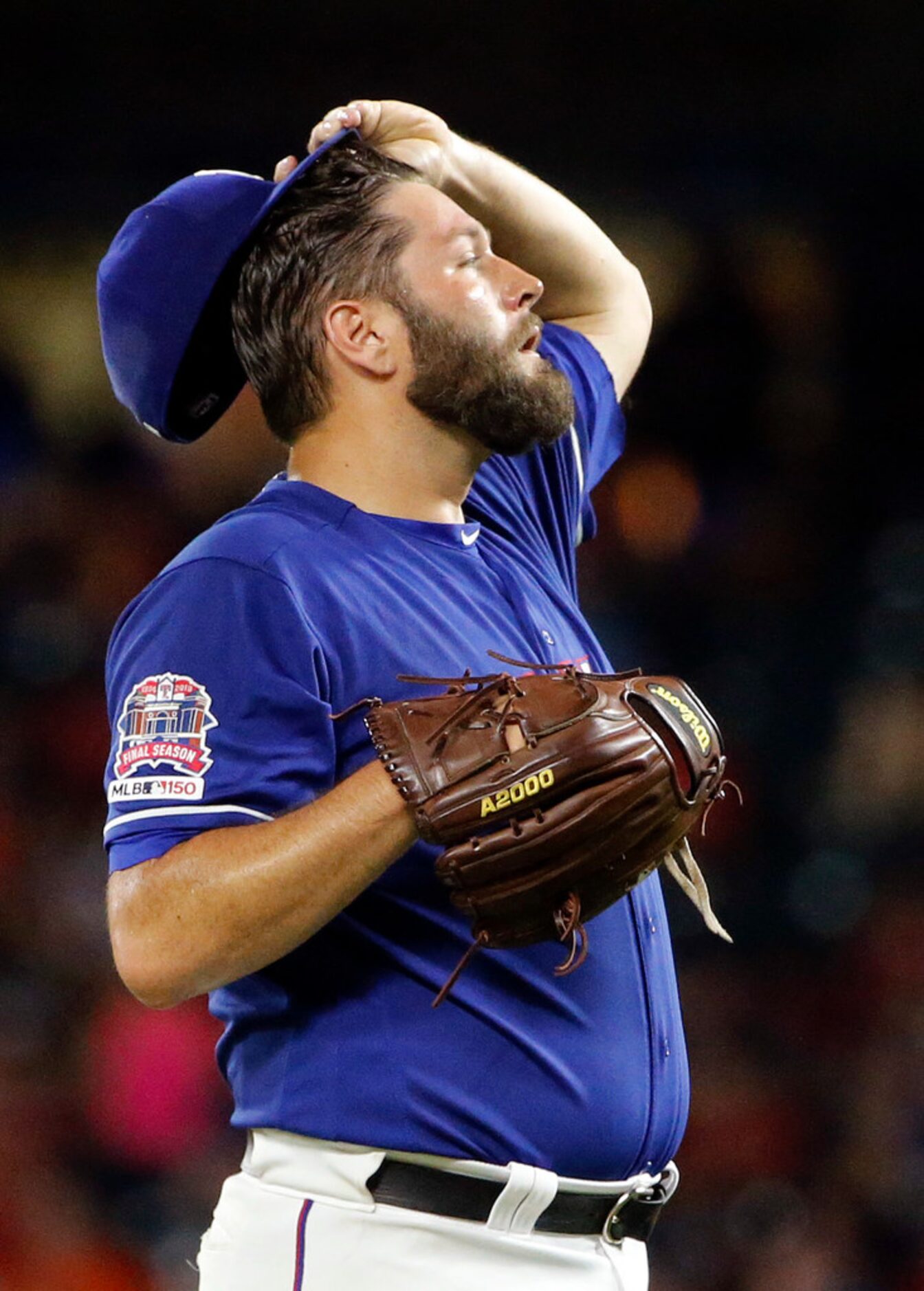 Texas Rangers starting pitcher Lance Lynn (35) takes a moment to wipe away the sweat before...