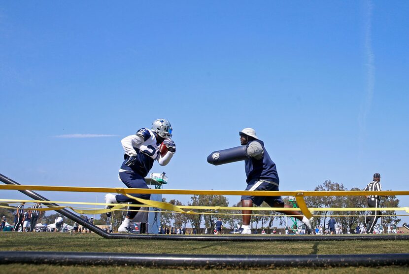 Dallas Cowboys running back Ezekiel Elliott, left, practices with running backs coach Gary...