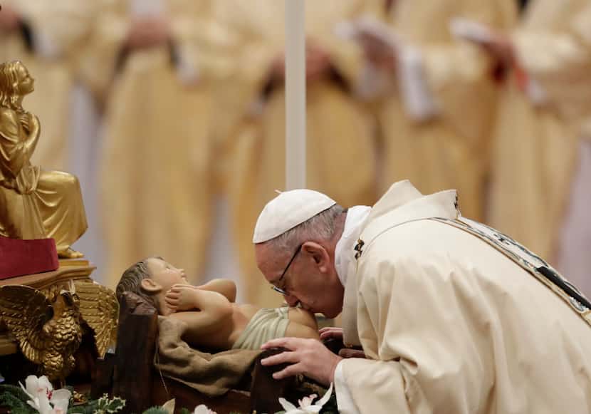 El papa Francisco besa una estatua del Divino Niño mientras celebra una misa de la Epifanía...