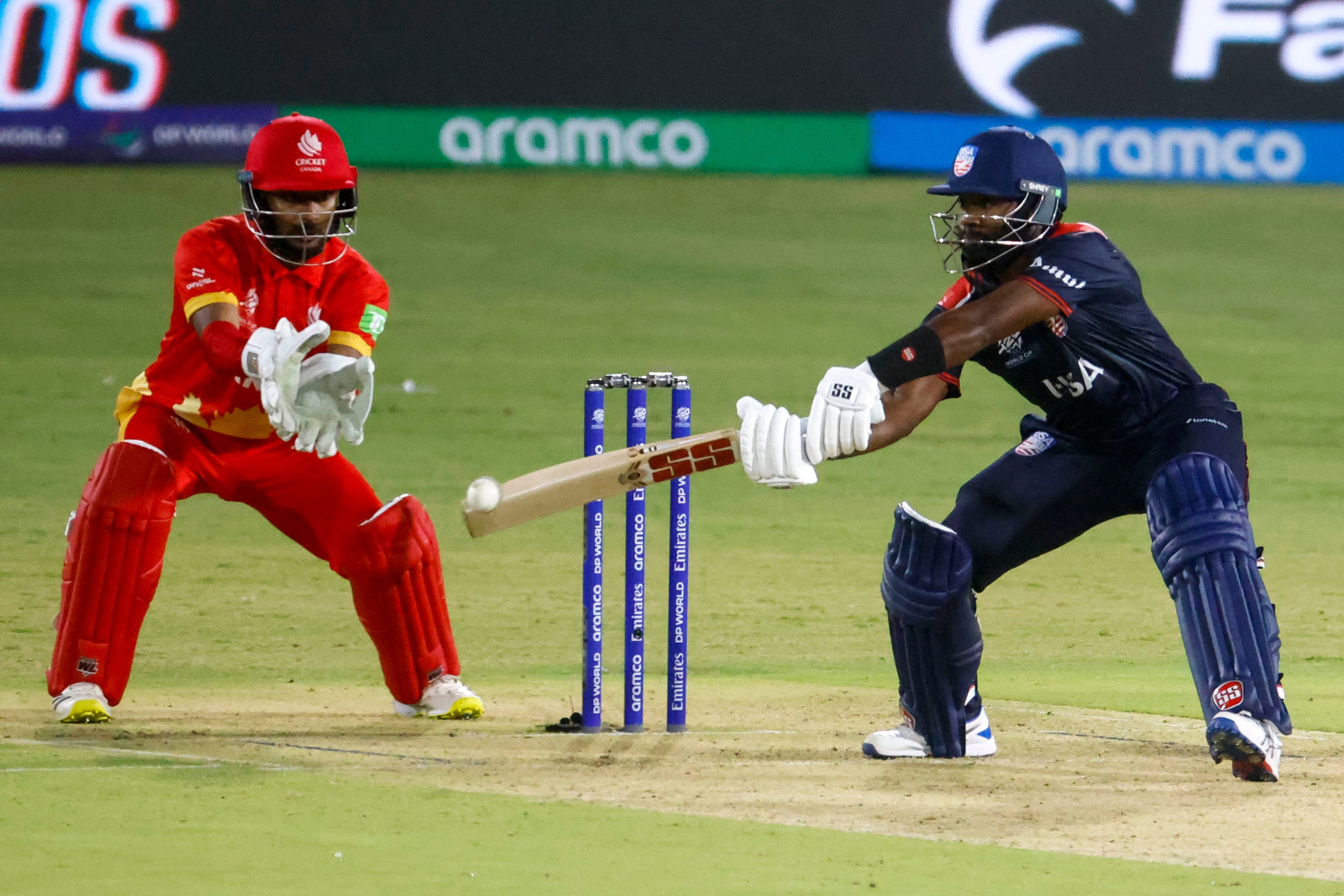 United States' Aaron (right) hits as Canda’s wicket keeper Shreyas Movva follows during the...