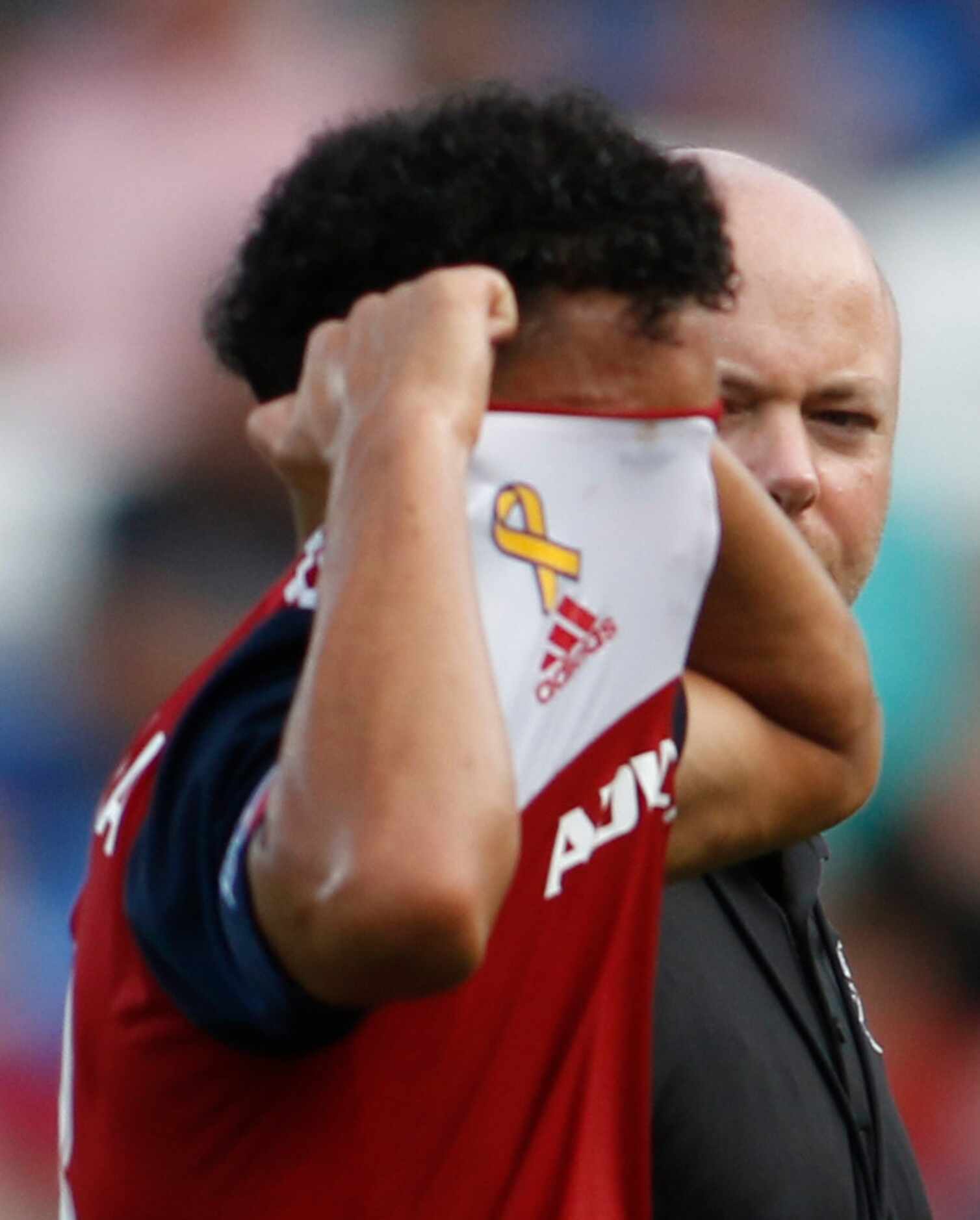 FC Dallas midfielder Brandon Servania (18) pulls his jersey over his face as he leaves the...