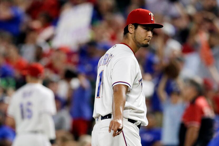 Texas Rangers' Yu Darvish points to plate umpire Paul Nauert, standing nearby, as Darvish...