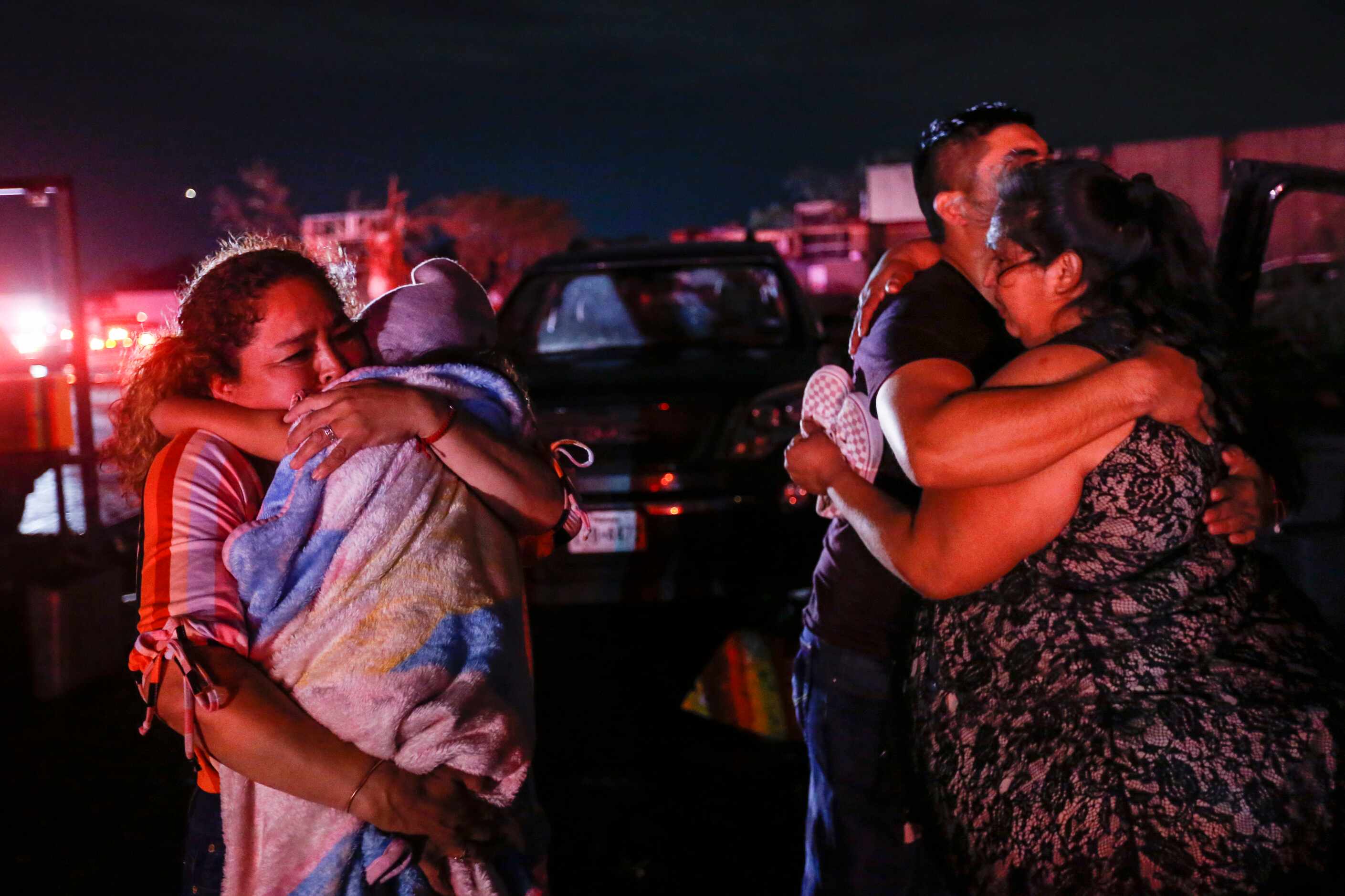 Family members embrace after reuniting after a storm near the intersection of Walnut Hill...