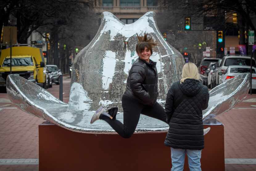 Bianca Moose leaps in front of the mirrored cowboy hat in Fort Worth's Sundance Square while...