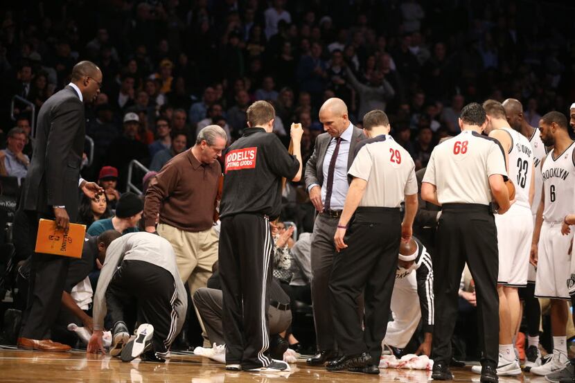 The court is cleaned after Brooklyn Nets Coach Jason Kidd spilled soda during a game against...