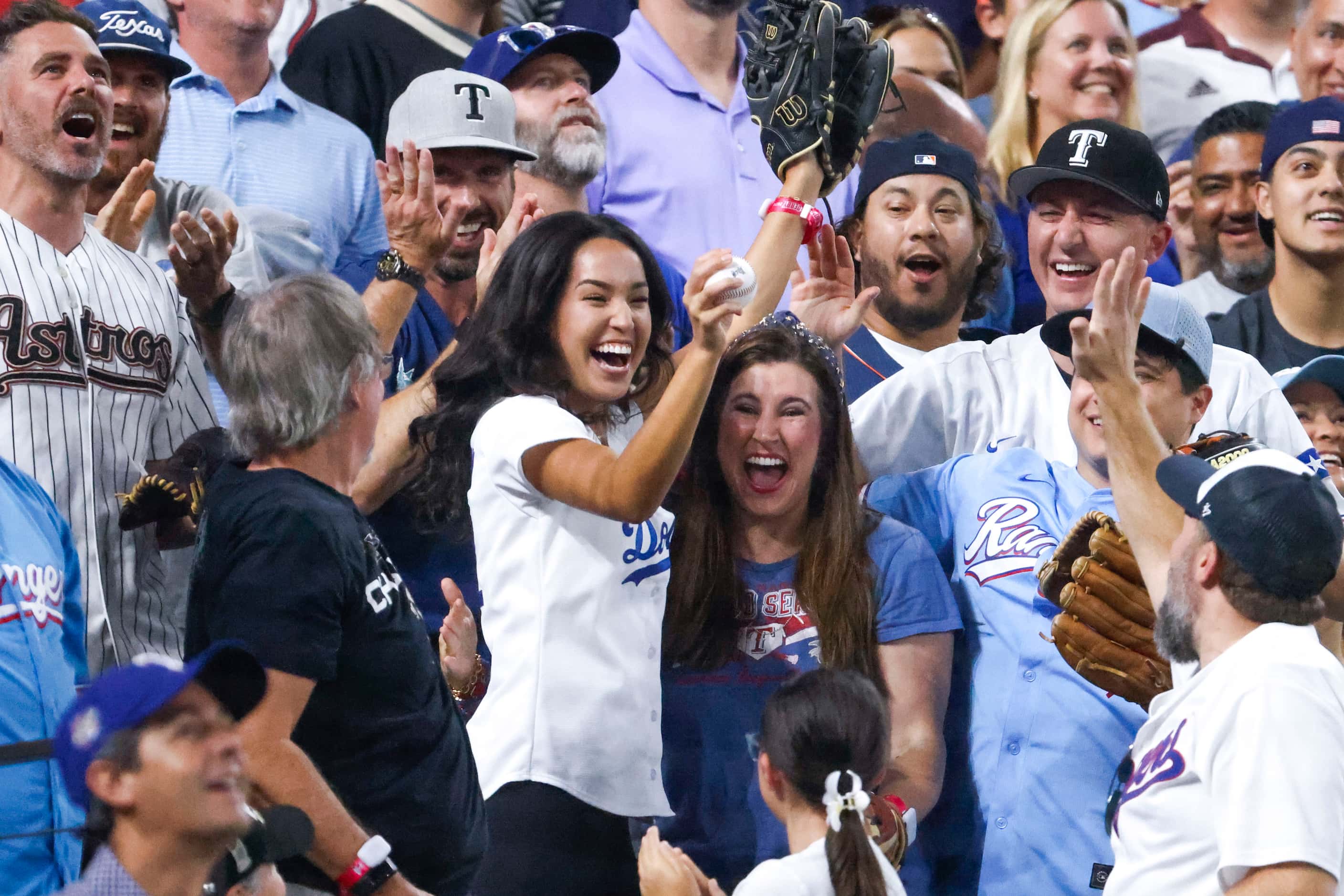 Crowd cheer after catching a homerun ball hit by Adolis Garcia of the Texas Rangers during...