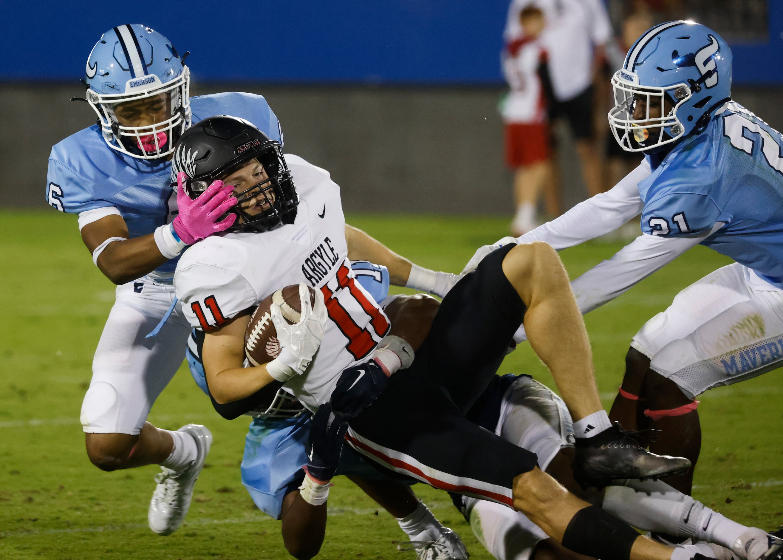 Argyle’s RJ Bunnell (11), center, gets tackled by Emerson’s Agape Lawrence (11), back, and...