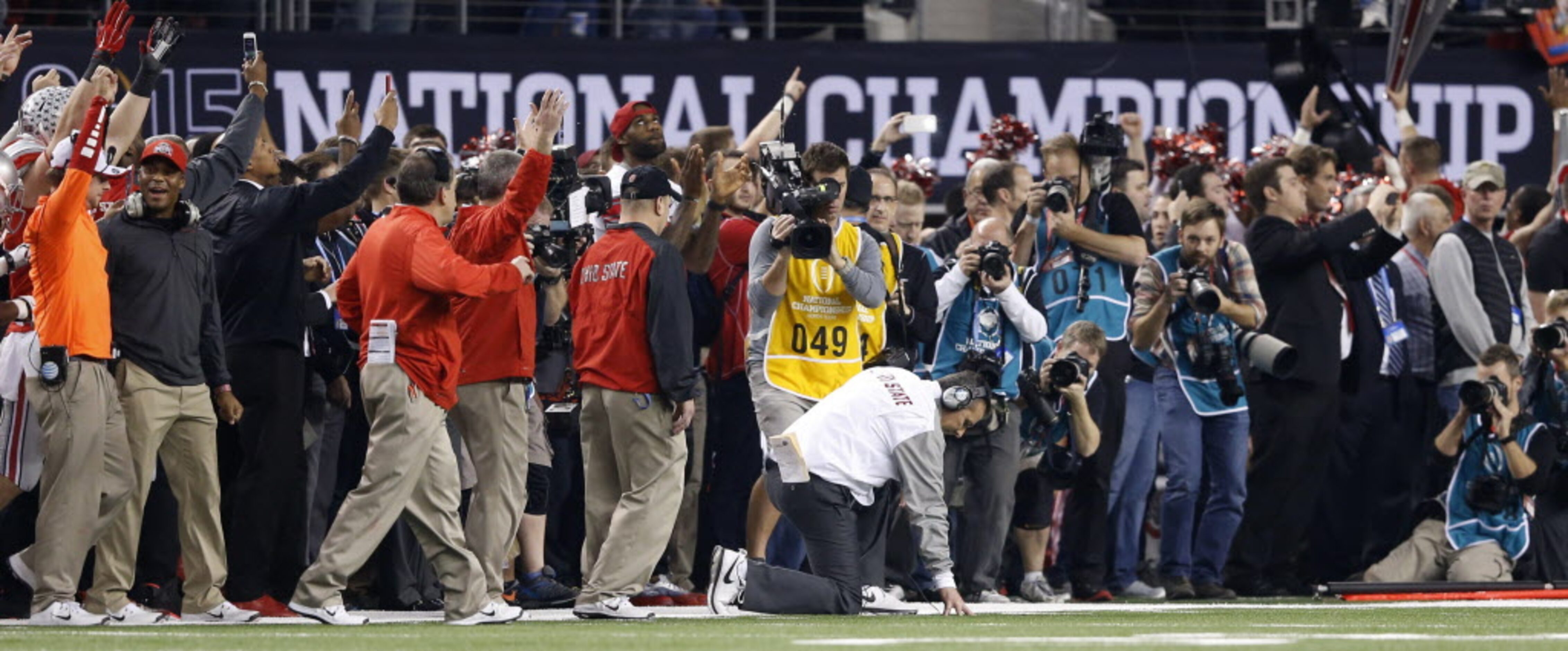 Ohio State Buckeyes head coach Urban Meyer falls to a knee and pauses as Ohio State Buckeyes...