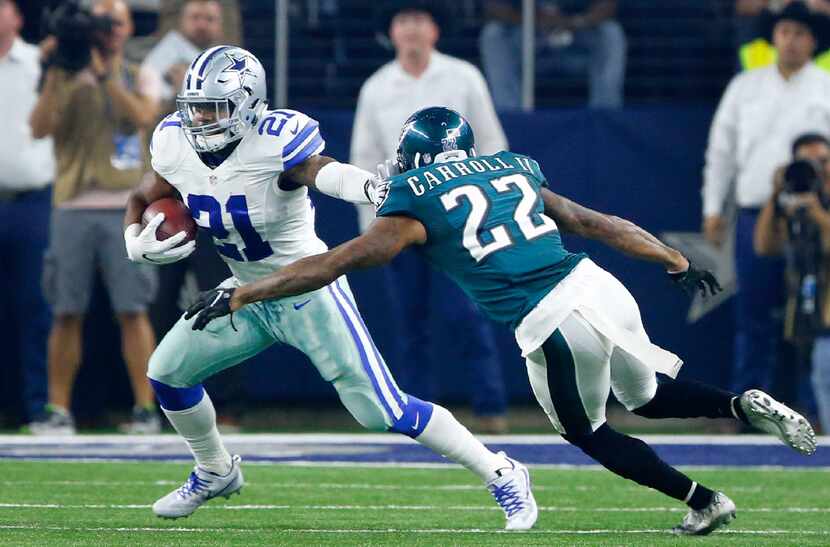 Dallas Cowboys running back Ezekiel Elliott (21) gives a stiff arm to Philadelphia Eagles...