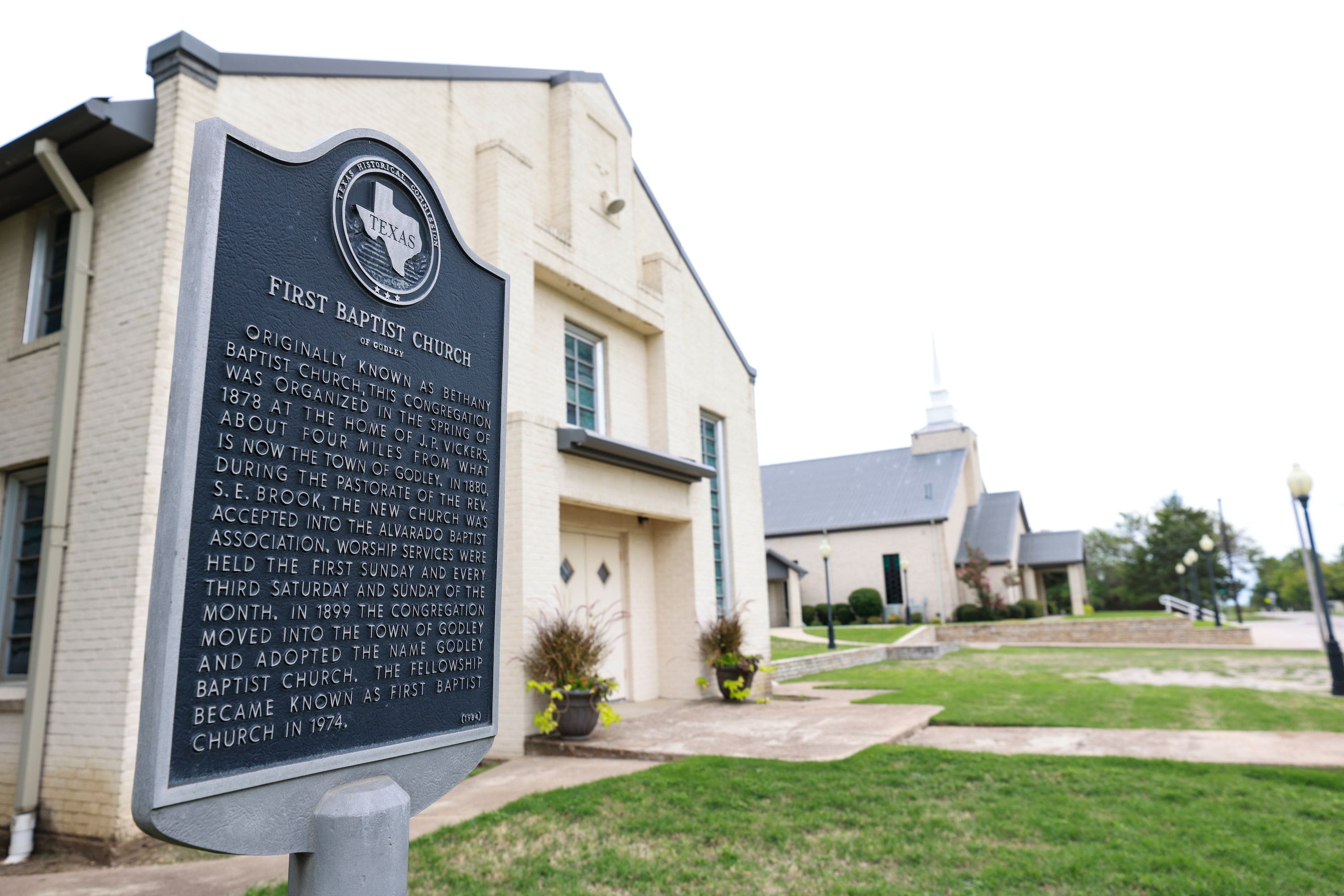 A historical marker at First Baptist Church in Godley. It says the church was originally...