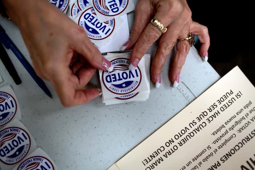 A poll worker gets "I Voted" stickers ready to hand to voters as they finished up at the...