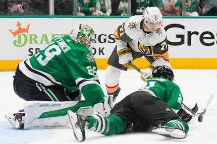 Dallas Stars left wing Jason Robertson (21) clears the puck in front of goaltender Jake...