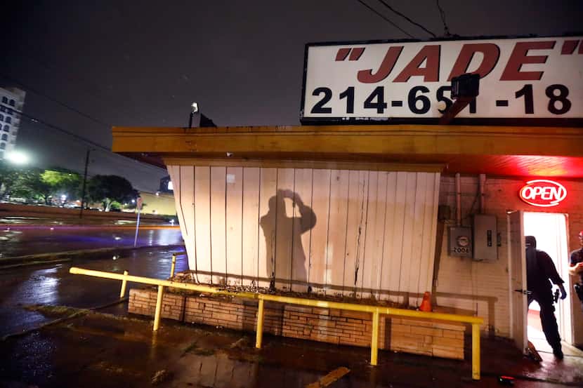 A Dallas Police vice officer takes photos of the outside of Jade Spa, a lucrative massage...