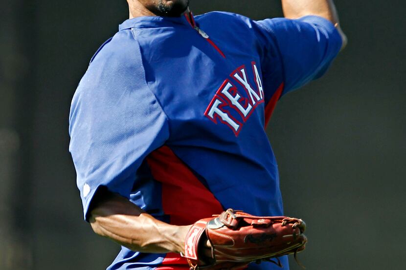 Texas Rangers outfielder Julio Borbon throws back the ball during spring training camp...