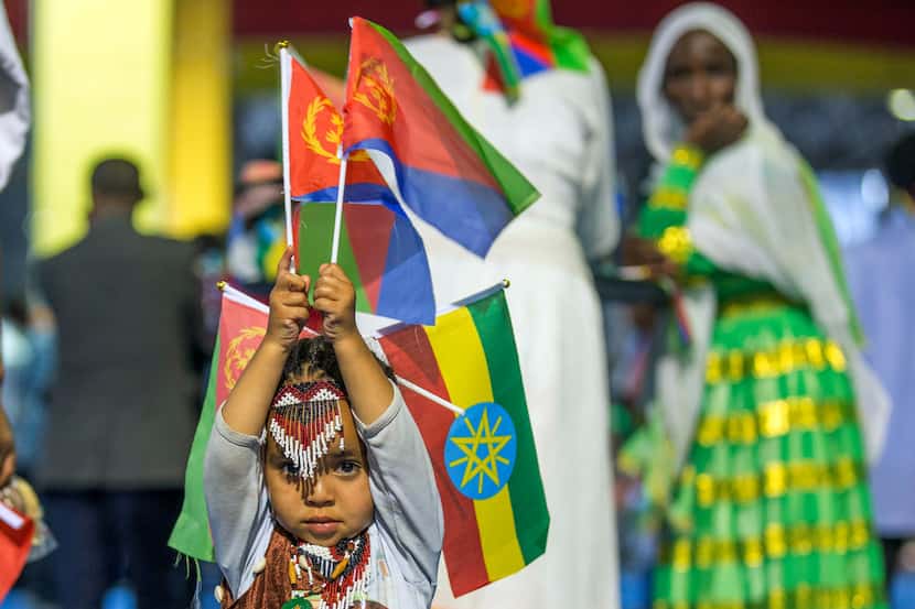 In this July 15, 2018 file photo, a child holds Ethiopian and Eritrean flags in the capital...