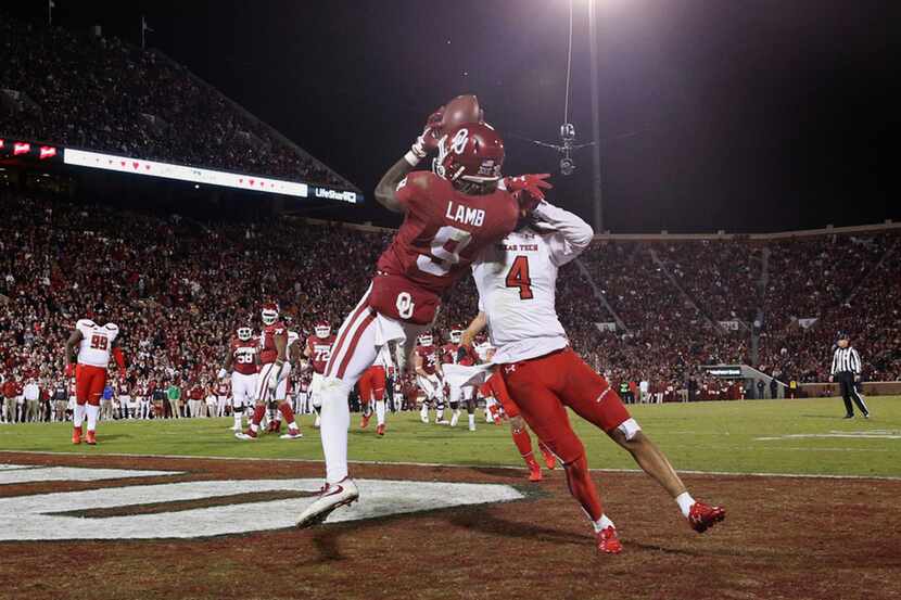Oklahoma wide receiver CeeDee Lamb (9) attempts to catch a touchdown pass while being...