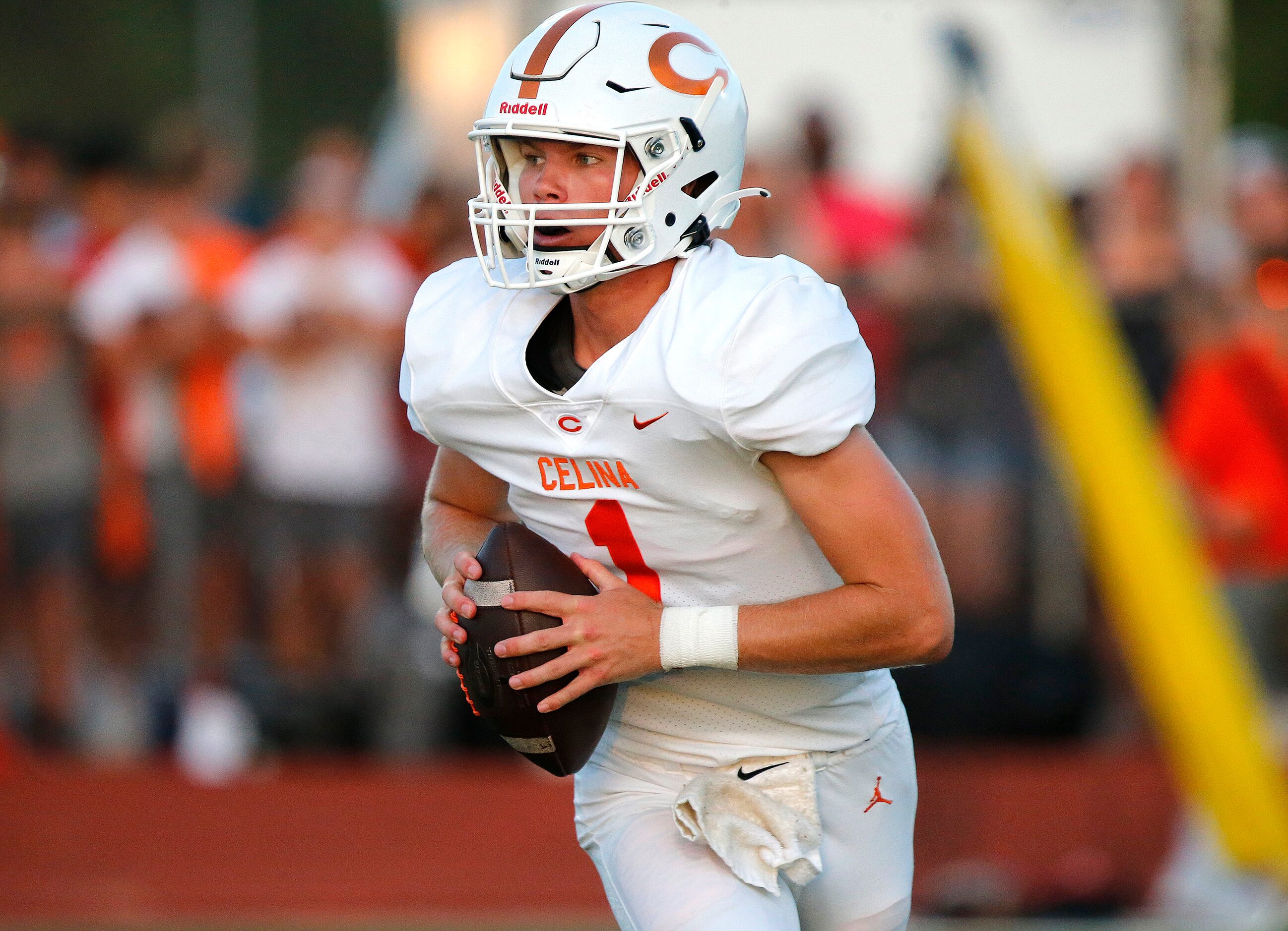 Celina High School quarterback Noah Bentley (1) rolls out to pass during the second half as...