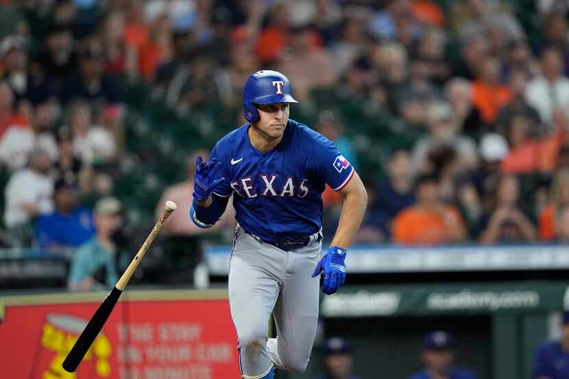Texas Rangers' Nathaniel Lowe drops his bat after hitting a RBI single against the Houston...