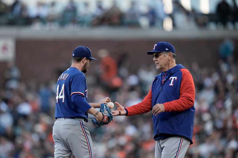 Texas Rangers pitcher Andrew Heaney, left, hands the ball over to manager Bruce Bochy while...