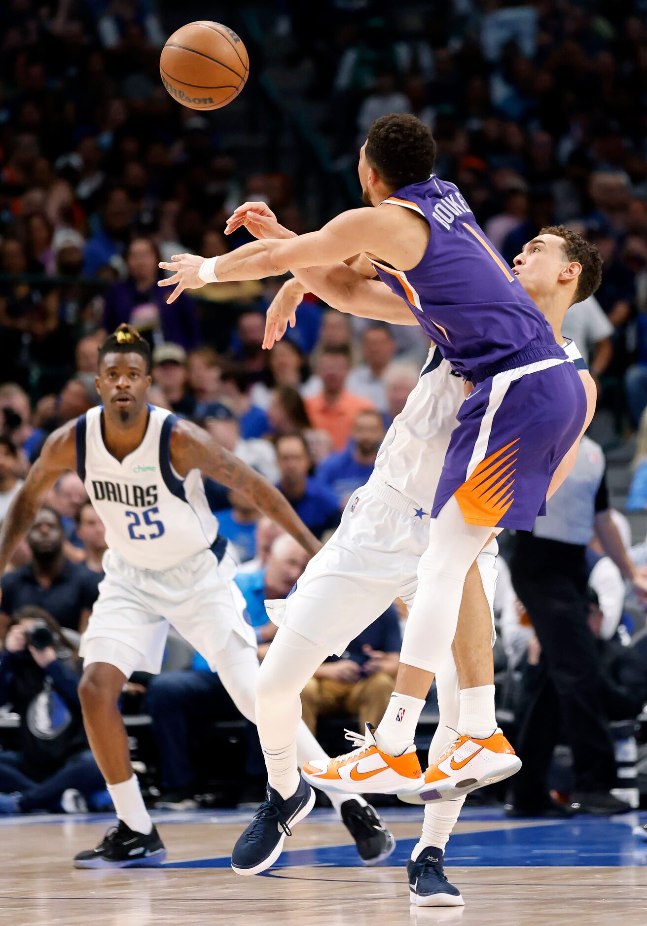 Dallas Mavericks center Dwight Powell (7) tries get defend Phoenix Suns guard Devin Booker...