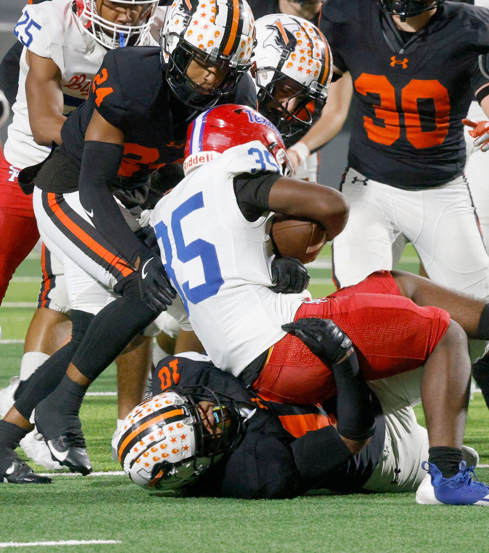 Sam Houston's Jokory Melbourne (35) is tackled by Haltom's Jayden Davis (10), bottom, as...