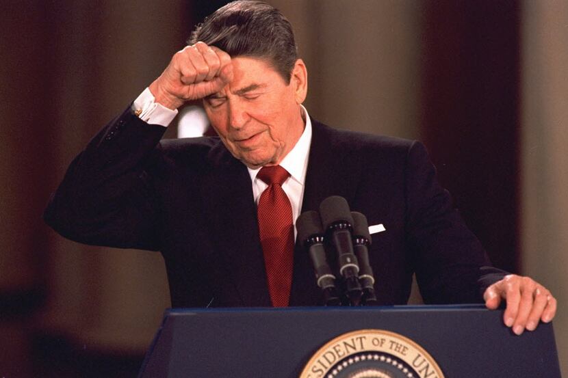 In this March 19, 1987 file photo, President Ronald Reagan taps his forehead at the White...