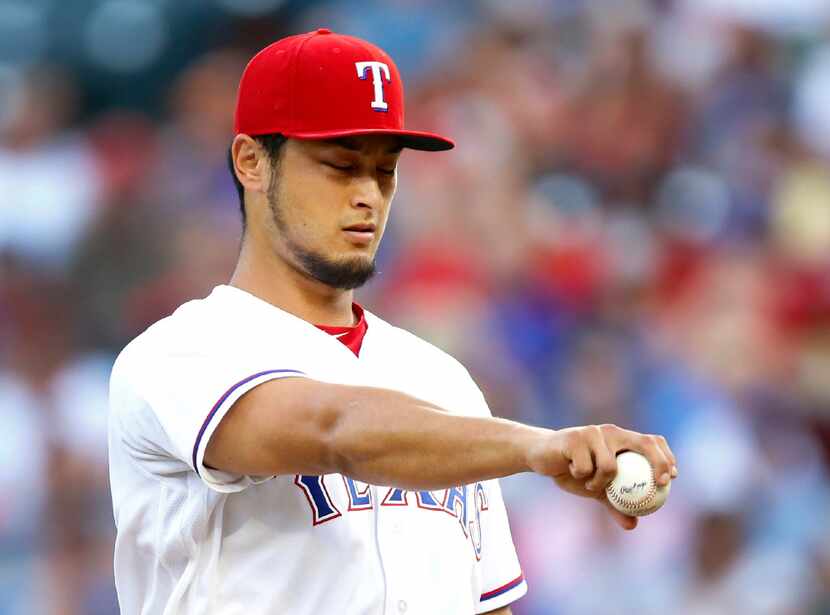 Texas Rangers starting pitcher Yu Darvish goes through his throwing mechanics on the mound...