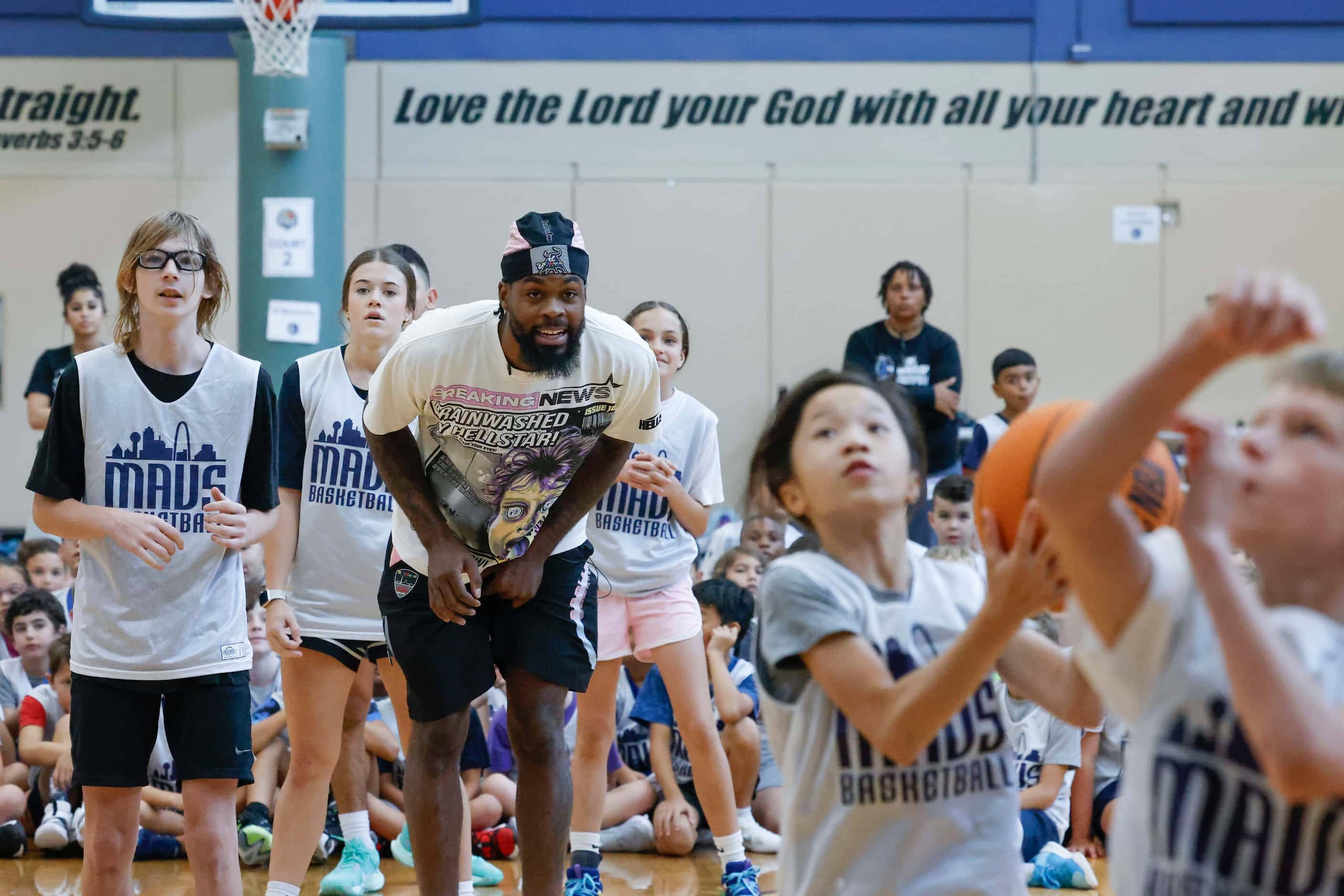 Dallas Mavericks’ Naji Marshall, watches as young basketball campers play ball during a Hoop...