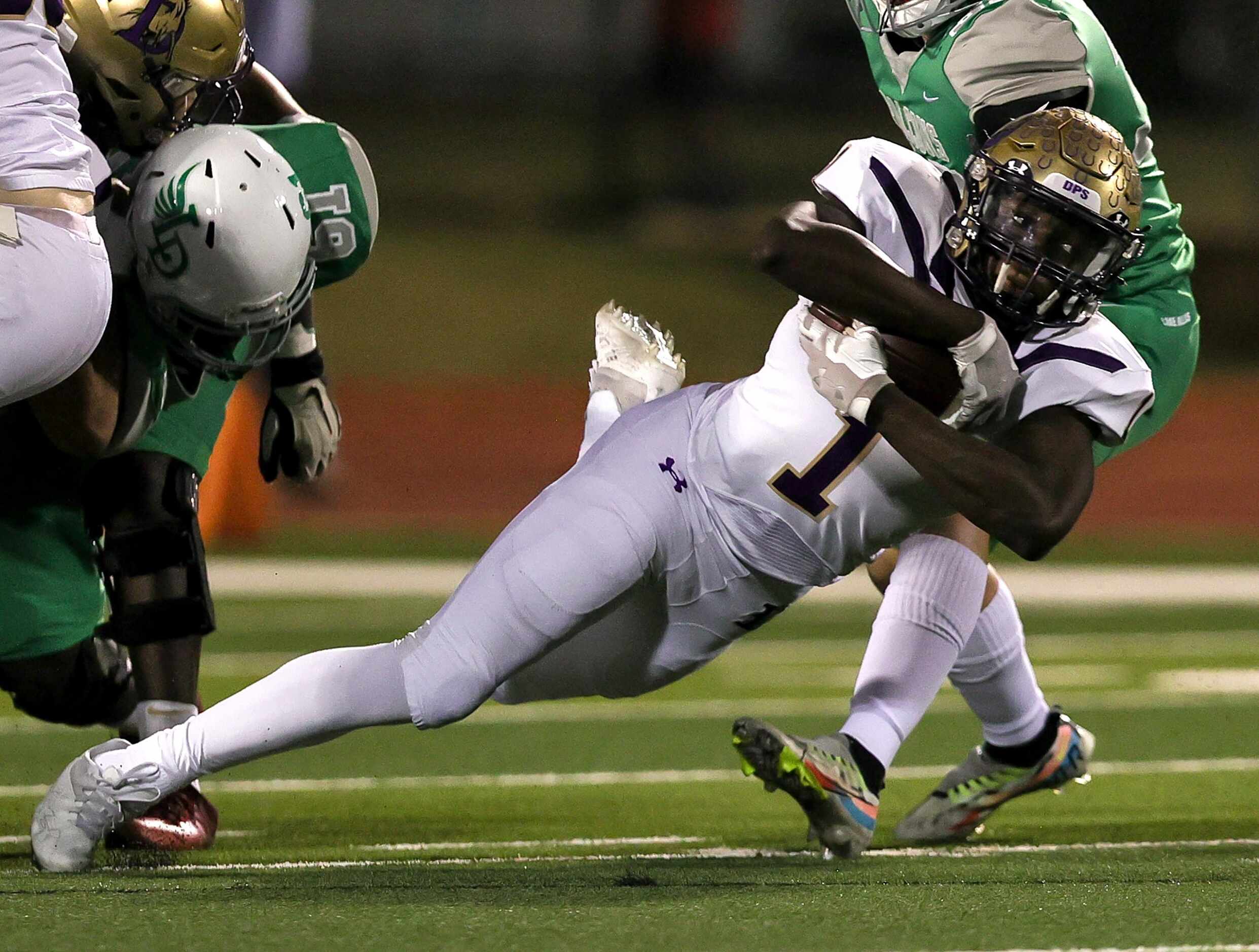 Denton running back Coco Brown gets tripped up against Lake Dallas during the first half of...