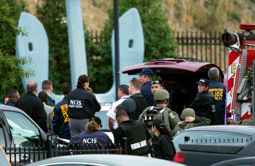 Security personnel respond Monday near the Washington Navy Yard, where at least one gunman...