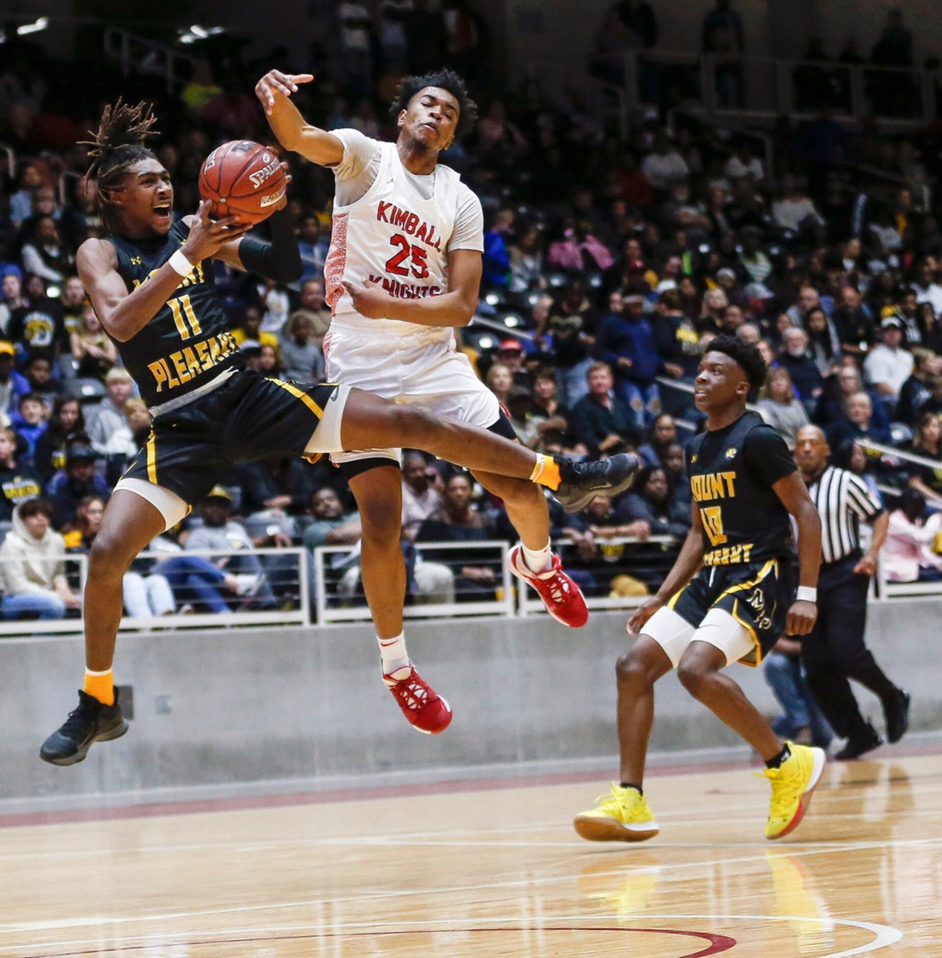 Mount Pleasant's Jamarion Brown (11) makes a rebound past Kimball's Marcus Bonner (25)...