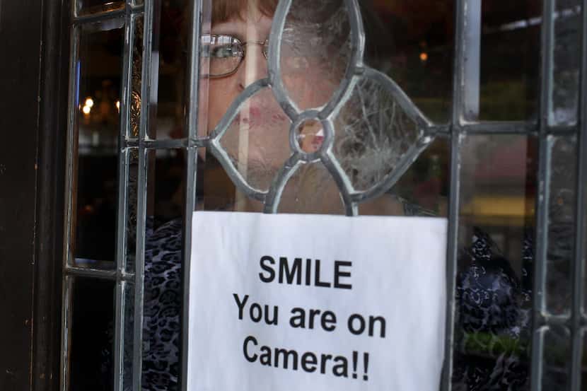 Seen through a doorway,  Cynthia Herndon, proprietor of Cozy Cottage Boutique in the Bishop...