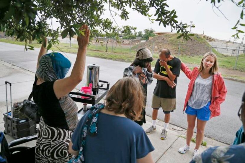 
Volunteer Elisabeth Jordan, with her hand on Julio Martinez, led a prayer at the conclusion...