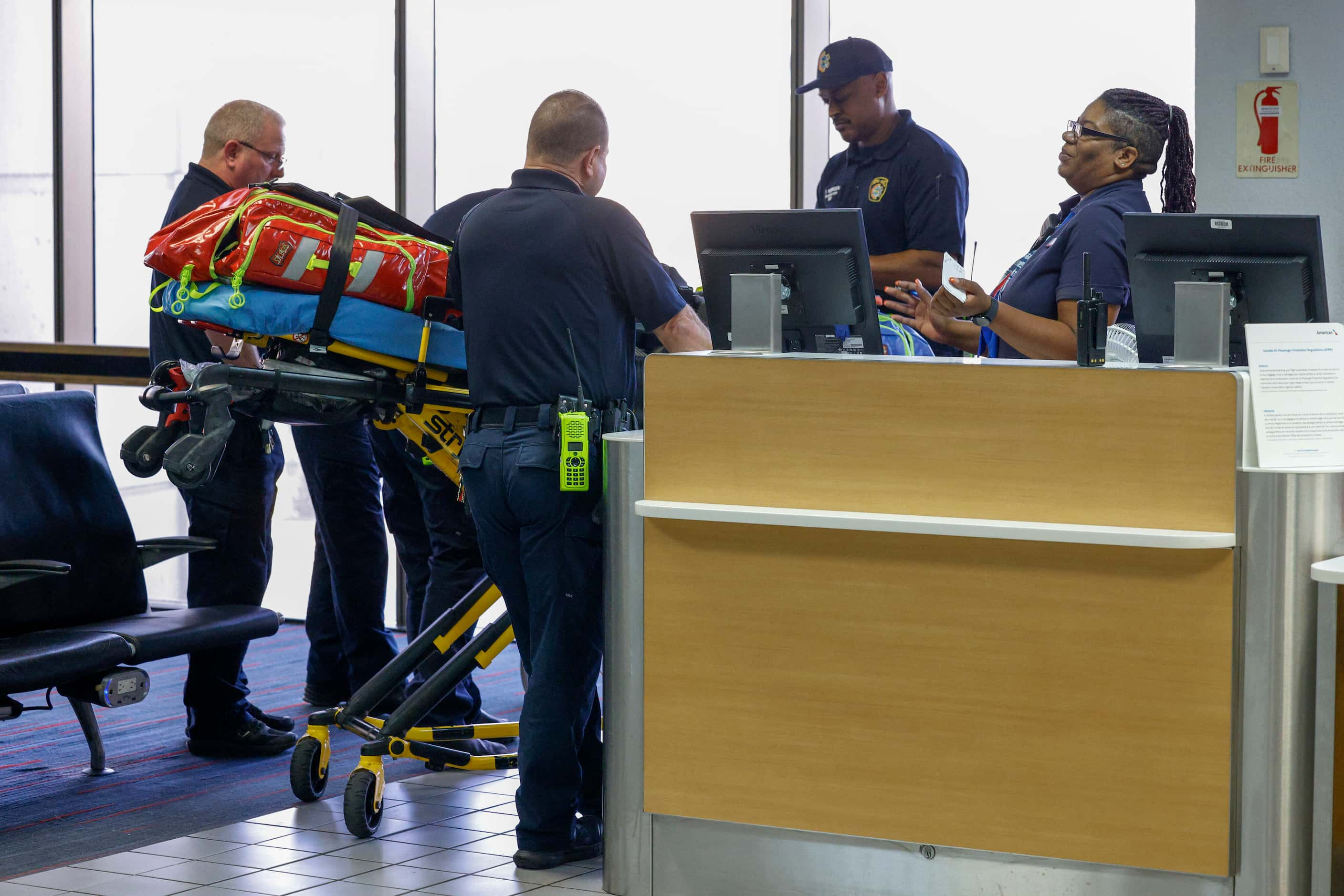 DFW Airport Fire Department firefighters and paramedics treat a traveler who passed out on a...