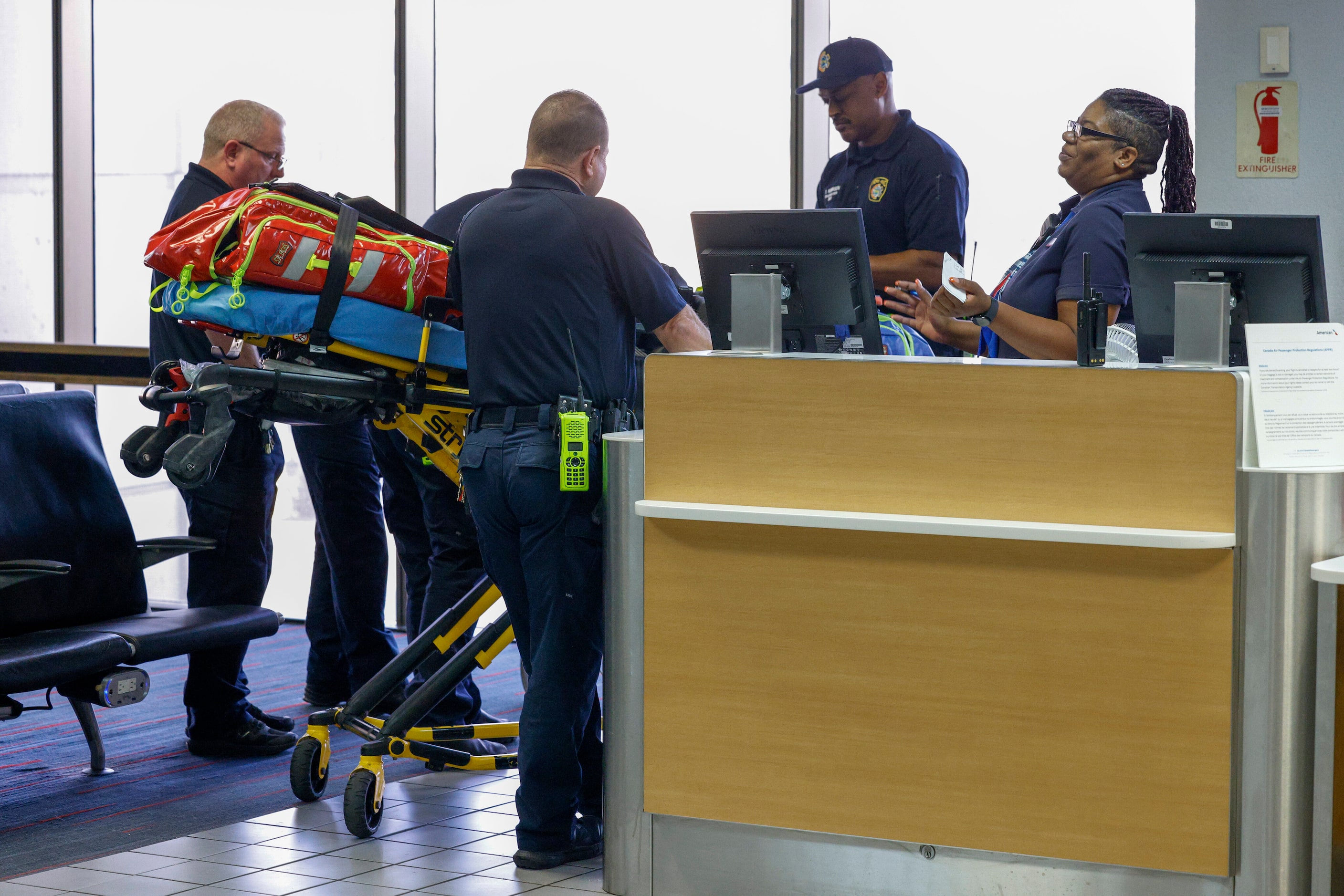 DFW Airport Fire Department firefighters and paramedics treat a traveler who passed out on a...